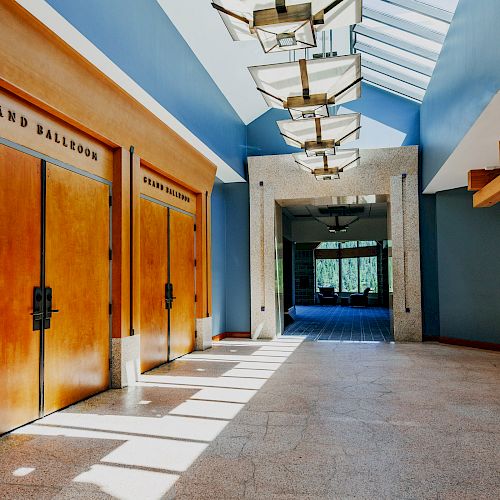 The image shows a corridor with wooden doors labeled 