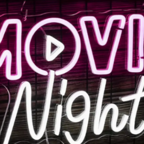 The image shows neon lights spelling "MOVIE Night" with a play icon inside the letter "O", set against a dark background.