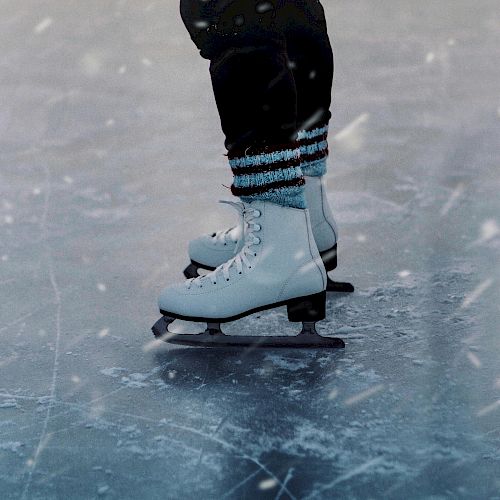 A person wearing white ice skates and blue-striped socks is gliding on an ice rink, with visible ice markings and a snowy texture.